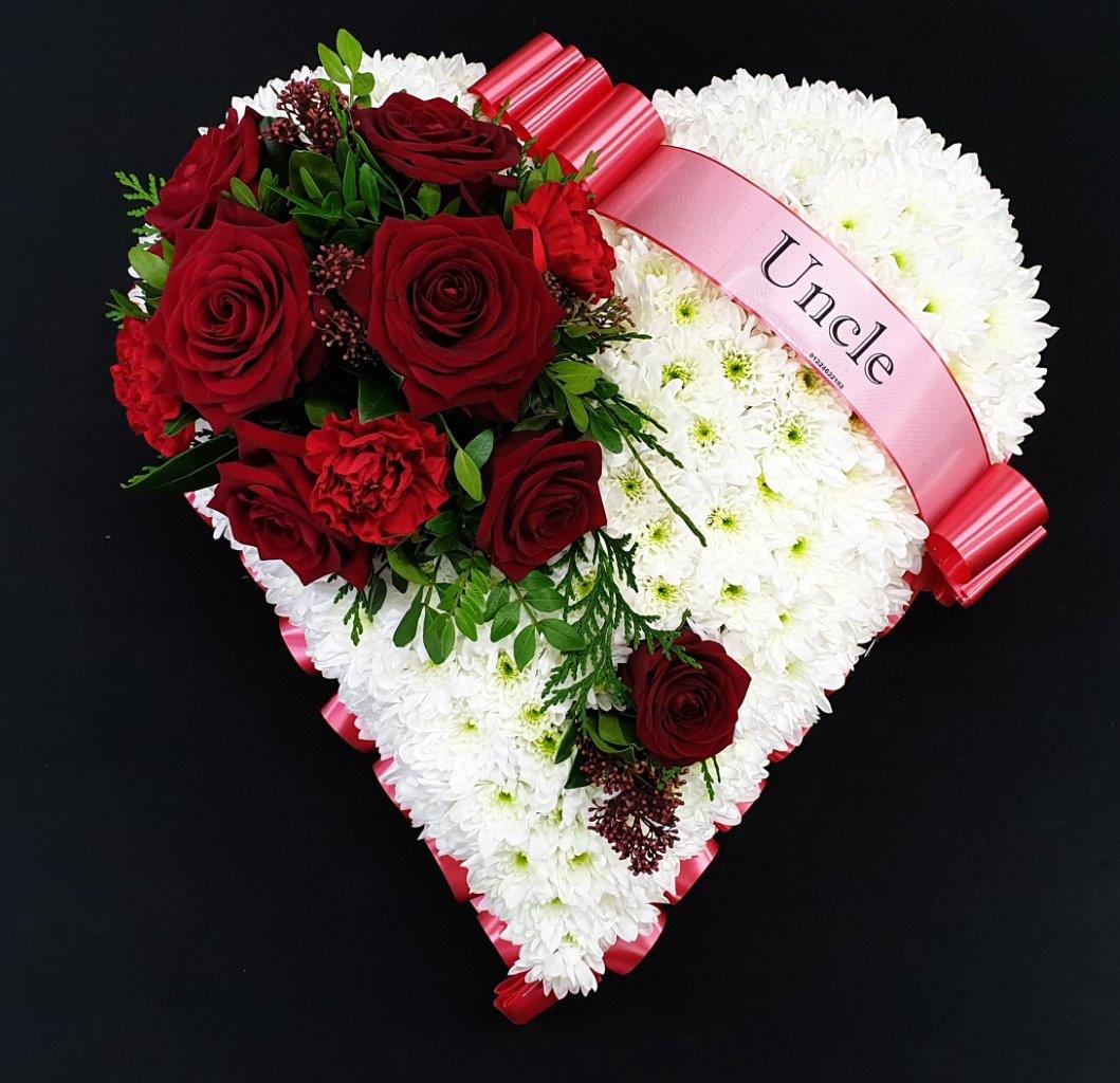 Funeral flower heart with white chrysanthemums and red roses.