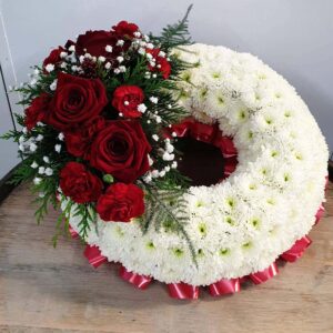 Funeral flower wreath with white chrysanthemums and red roses