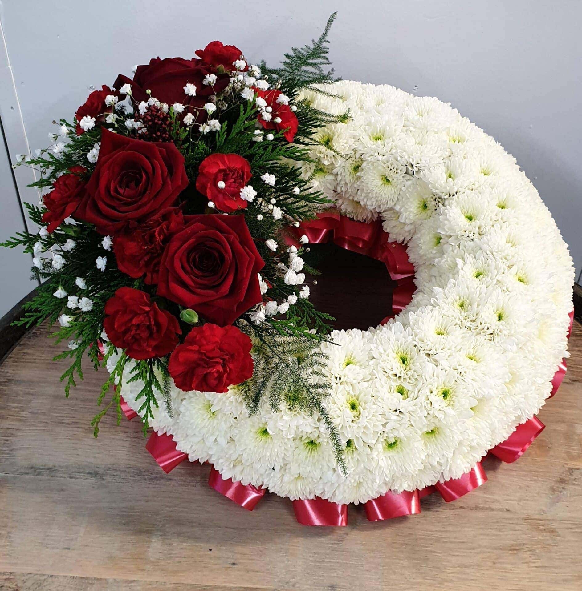 Funeral flower wreath with white chrysanthemums and red roses