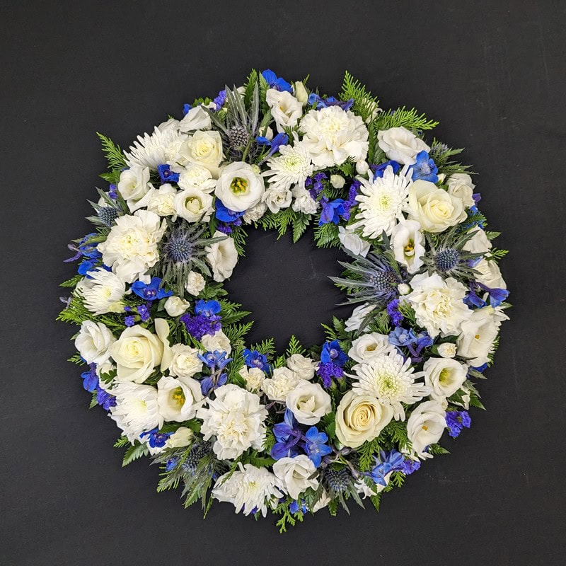 White and blue funeral flower wreath with roses and chrysanthemums
