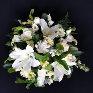 White lily and rose funeral posy with cream flowers and green foliage