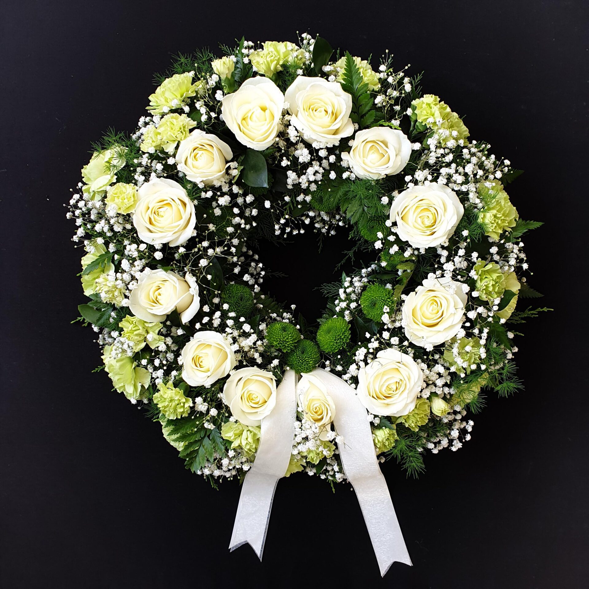 White rose and greenery funeral wreath tribute
