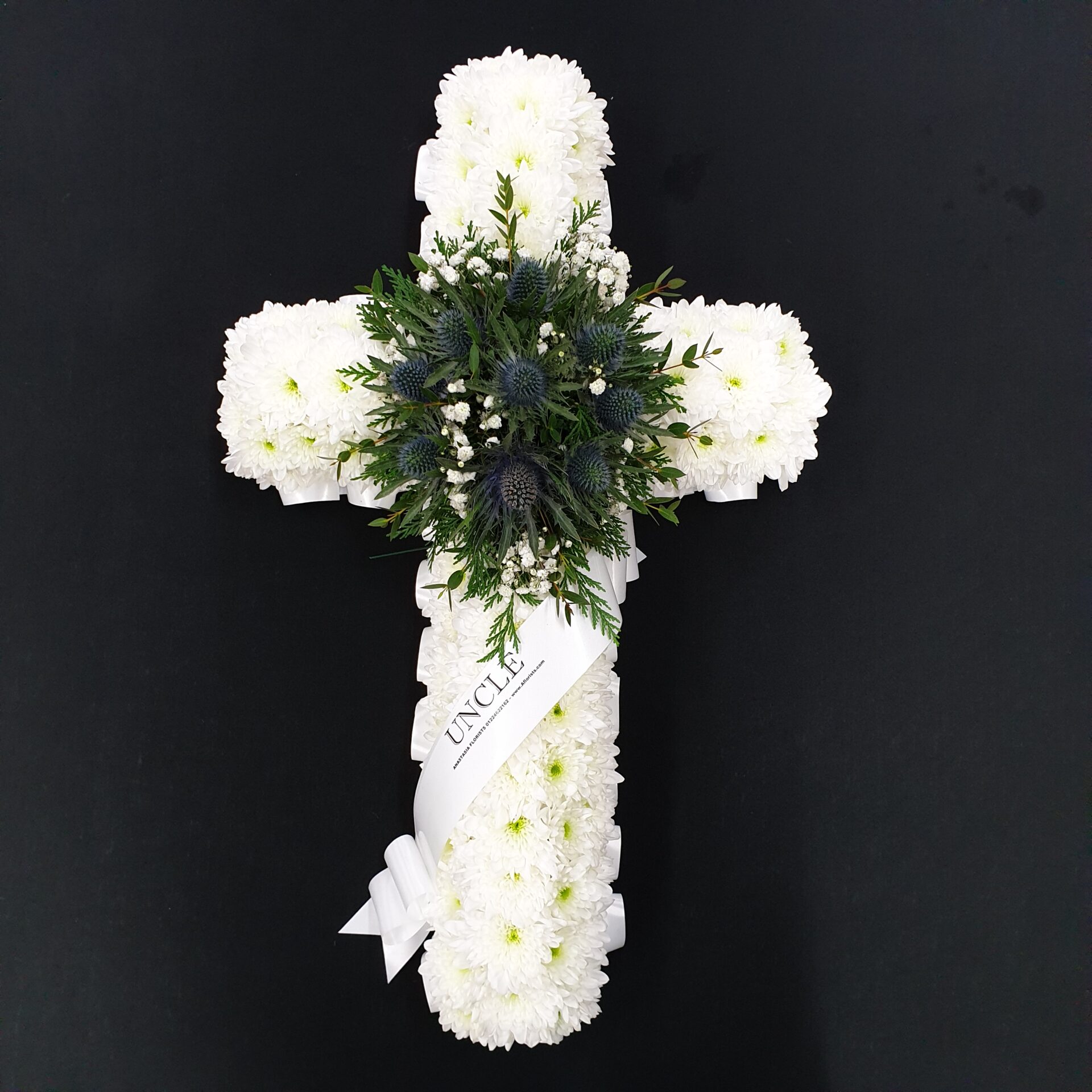 White chrysanthemum funeral cross with blue thistles and Uncle ribbon