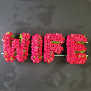 WIFE funeral letter tribute made from pink roses with green foliage